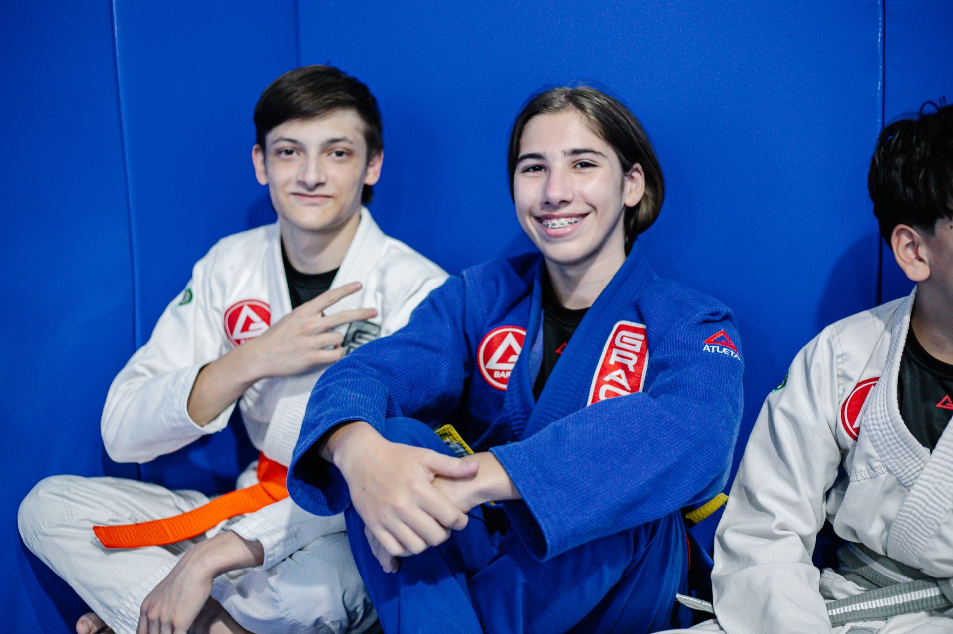 Alunos adolescentes da Gracie Barra Tubarão no tatame, com um aluno de faixa laranja